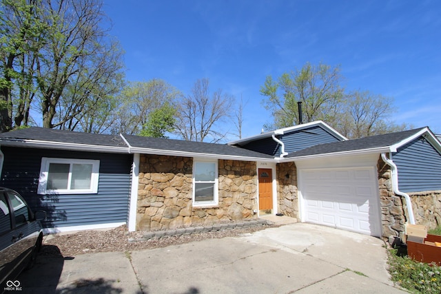 3836 N Wittfield St, Indianapolis, IN 46235 - view of front of house with stone siding, a garage, concrete driveway, and a shingled roof