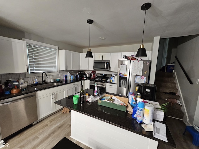 3836 N Wittfield St, Indianapolis, IN 46235 - kitchen with stainless steel appliances, light wood finished floors, dark countertops, tasteful backsplash, and white cabinetry