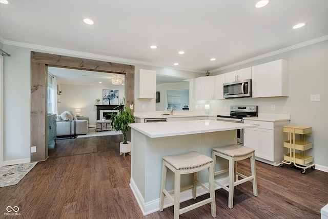 6036 W Bayfront Shrs, Mccordsville, IN 46055 - kitchen with stainless steel appliances, dark wood-type flooring, a breakfast bar area, ornamental molding, and white cabinetry