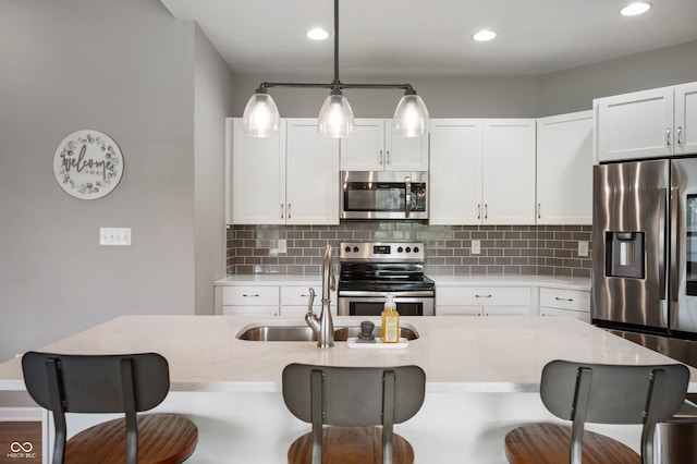 6420 Colt Ln, Anderson, IN 46013 - kitchen featuring appliances with stainless steel finishes, a breakfast bar, white cabinetry, backsplash, and recessed lighting