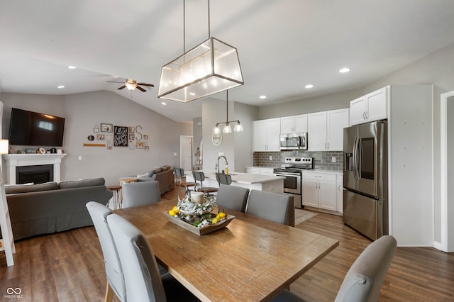 6420 Colt Ln, Anderson, IN 46013 - dining room featuring dark wood finished floors, ceiling fan, a fireplace, recessed lighting, and vaulted ceiling