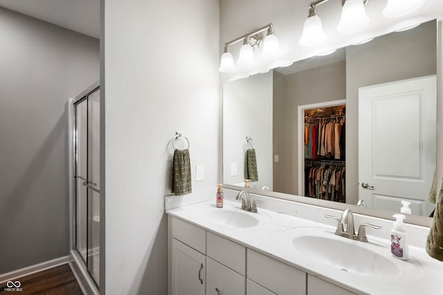 6420 Colt Ln, Anderson, IN 46013 - full bath with a stall shower, double vanity, a walk in closet, and wood finished floors
