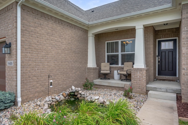 6420 Colt Ln, Anderson, IN 46013 - doorway to property featuring a porch, a shingled roof, and brick siding