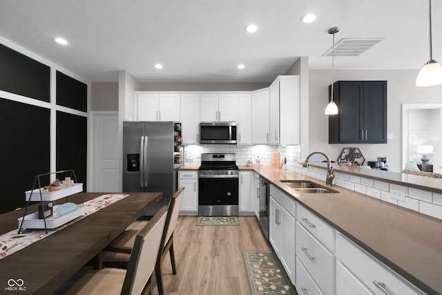 757 Carson Ln, Greenfield, IN 46140 - kitchen featuring stainless steel appliances, light wood-style floors, backsplash, decorative light fixtures, and white cabinets