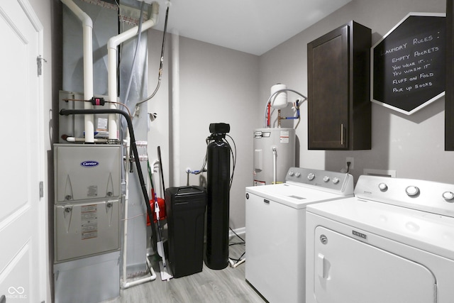 757 Carson Ln, Greenfield, IN 46140 - laundry room featuring electric water heater, cabinet space, washing machine and clothes dryer, light wood-style flooring, and heating unit