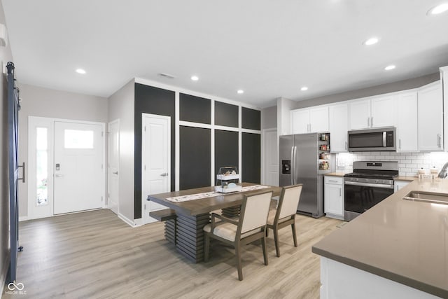 757 Carson Ln, Greenfield, IN 46140 - kitchen featuring stainless steel appliances, backsplash, light wood finished floors, white cabinets, and recessed lighting