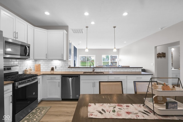 757 Carson Ln, Greenfield, IN 46140 - kitchen featuring appliances with stainless steel finishes, dark countertops, light wood-style flooring, tasteful backsplash, and recessed lighting
