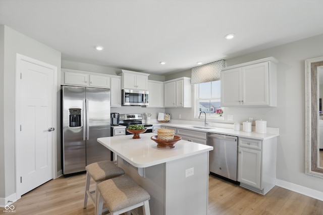 4182 Hume Ave, Plainfield, IN 46168 - kitchen with stainless steel appliances, white cabinets, a kitchen island, a kitchen bar, and light countertops