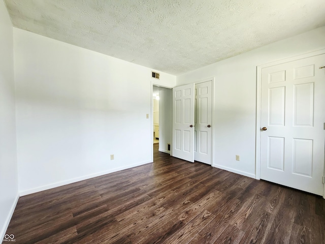 3415 Winchester Dr, Indianapolis, IN 46227 - unfurnished bedroom featuring dark wood-style flooring and a textured ceiling