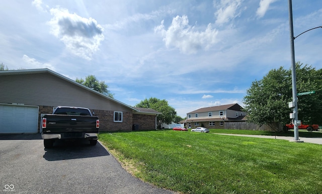 3415 Winchester Dr, Indianapolis, IN 46227 - view of side of property featuring brick siding, a yard, a garage, and driveway