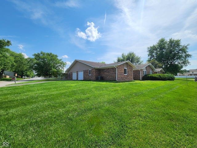 3415 Winchester Dr, Indianapolis, IN 46227 - view of property exterior featuring a garage, brick siding, and a yard