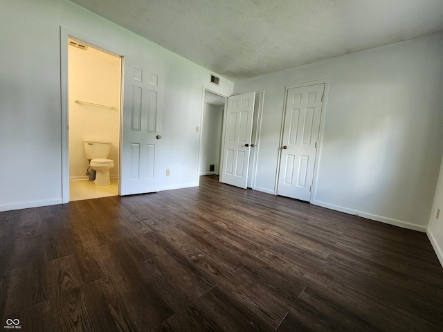 3415 Winchester Dr, Indianapolis, IN 46227 - unfurnished bedroom with dark wood-type flooring, ensuite bath, and a textured ceiling