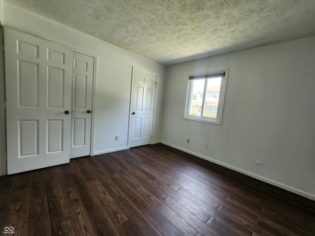 3415 Winchester Dr, Indianapolis, IN 46227 - unfurnished bedroom featuring a textured ceiling and dark wood-type flooring