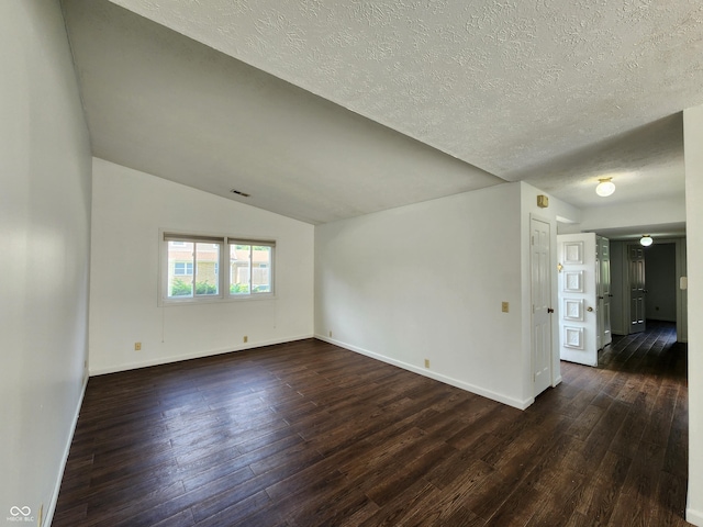 3415 Winchester Dr, Indianapolis, IN 46227 - empty room with dark wood-style flooring, lofted ceiling, and a textured ceiling