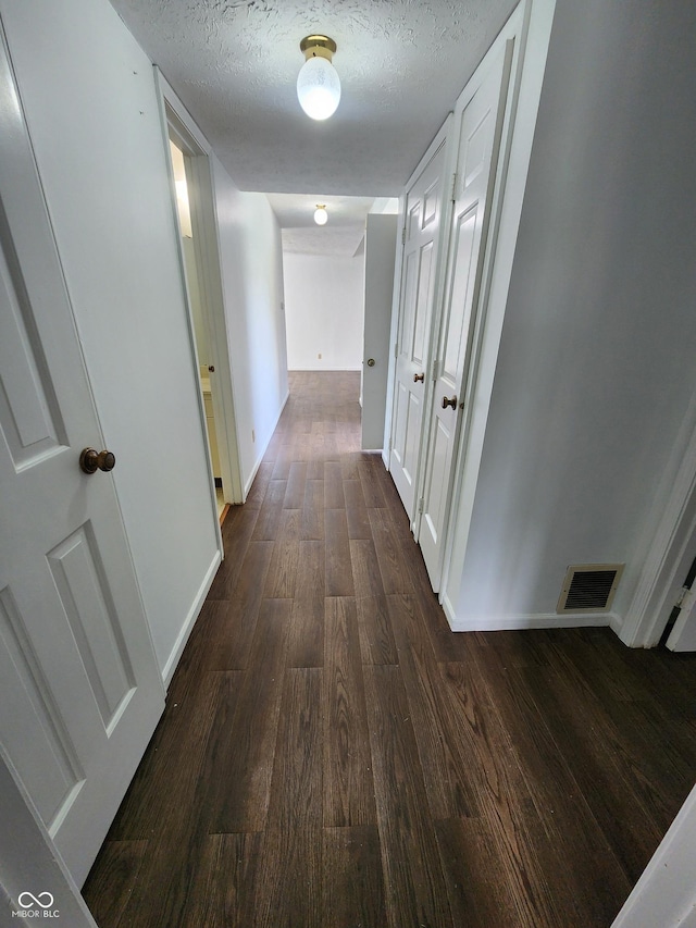 3415 Winchester Dr, Indianapolis, IN 46227 - corridor with dark wood finished floors and a textured ceiling