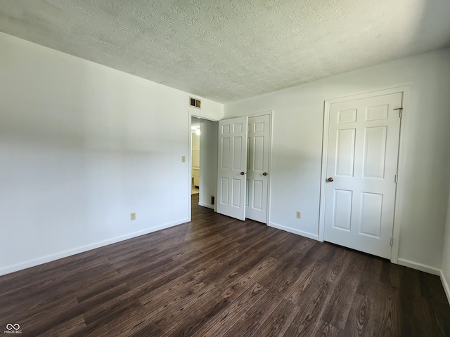 3415 Winchester Dr, Indianapolis, IN 46227 - unfurnished bedroom featuring dark wood-style floors, a textured ceiling, and a closet