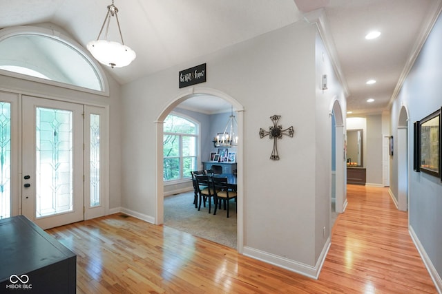 5720 Hickory Hollow Dr, Plainfield, IN 46168 - foyer entrance featuring arched walkways, light wood finished floors, lofted ceiling, crown molding, and a chandelier