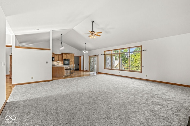 3766 Brill Rd, Indianapolis, IN 46227 - unfurnished living room featuring a ceiling fan, light colored carpet, lofted ceiling, and a chandelier