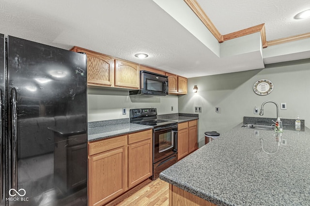 3766 Brill Rd, Indianapolis, IN 46227 - kitchen with black appliances, ornamental molding, light wood-style floors, and dark stone countertops