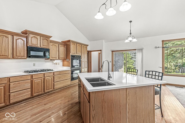 3766 Brill Rd, Indianapolis, IN 46227 - kitchen with black appliances, light wood-style floors, a kitchen bar, light countertops, and a chandelier