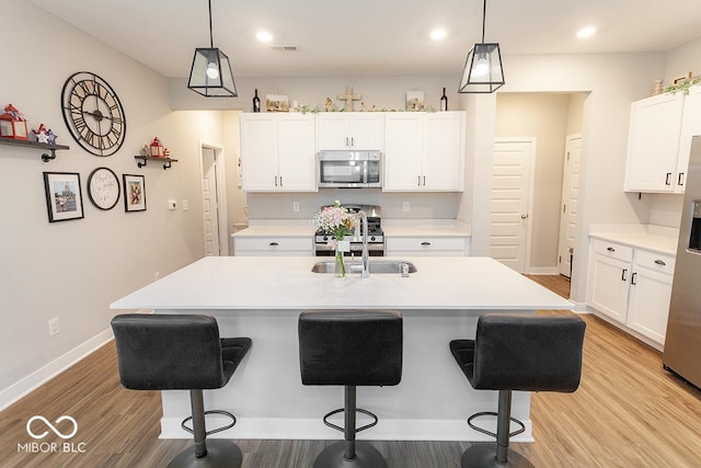 9309 Kellner St, Pendleton, IN 46064 - kitchen featuring stainless steel appliances, a kitchen breakfast bar, light wood finished floors, light countertops, and recessed lighting