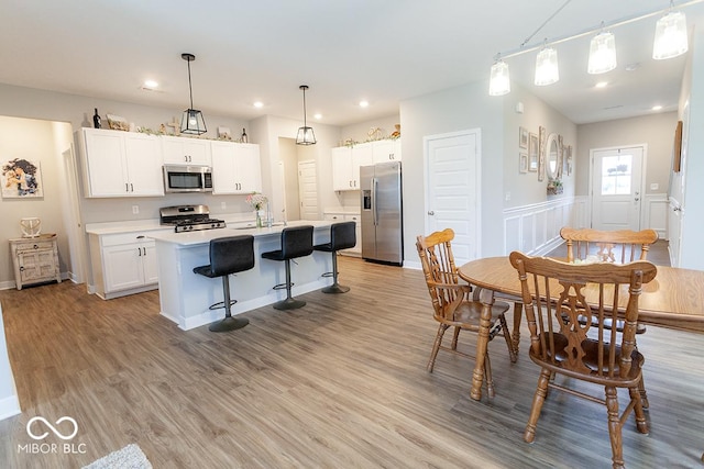 9309 Kellner St, Pendleton, IN 46064 - kitchen featuring stainless steel appliances, light countertops, white cabinetry, a center island with sink, and recessed lighting
