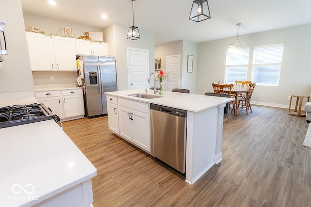 9309 Kellner St, Pendleton, IN 46064 - kitchen with appliances with stainless steel finishes, light wood-style flooring, light countertops, hanging light fixtures, and white cabinets