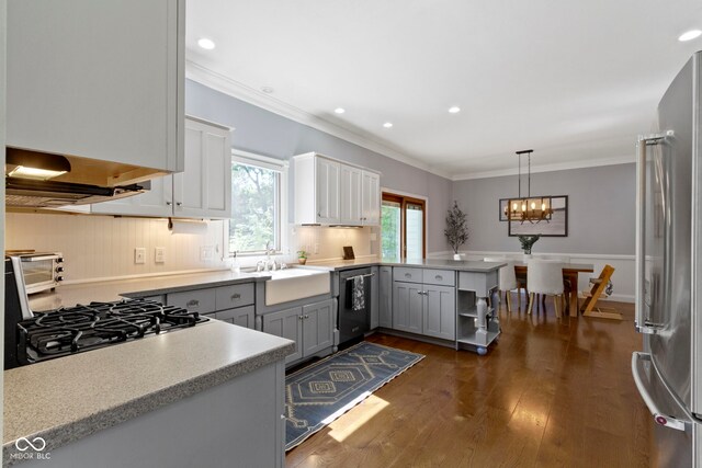 111 N 8th St, Zionsville, IN 46077 - kitchen with stainless steel appliances, gray cabinetry, a peninsula, dark wood-style flooring, and a chandelier