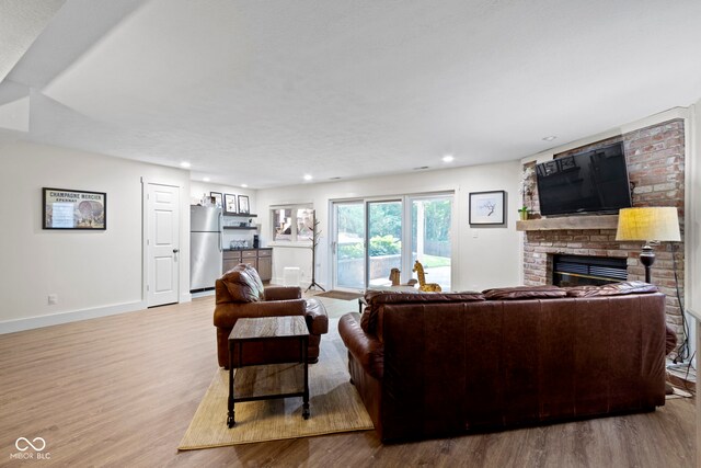 111 N 8th St, Zionsville, IN 46077 - living area featuring wood finished floors, a brick fireplace, and recessed lighting