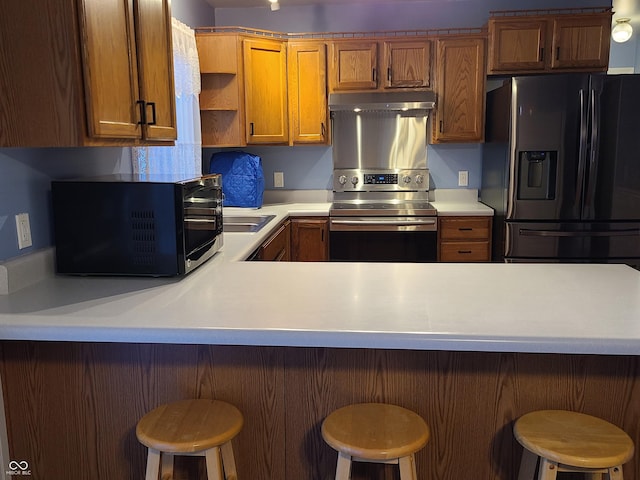 6052 N Deckshire Ln, Shirley, IN 47384 - kitchen featuring black appliances, light countertops, open shelves, under cabinet range hood, and brown cabinetry