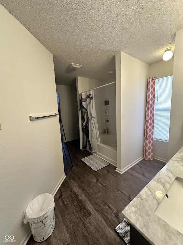 12536 Teacup Way NE, Indianapolis, IN 46235 - bathroom featuring a textured ceiling, wood finished floors, vanity, and shower / bath combo