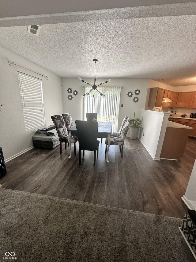 12536 Teacup Way NE, Indianapolis, IN 46235 - dining space with dark wood finished floors, a textured ceiling, and a chandelier