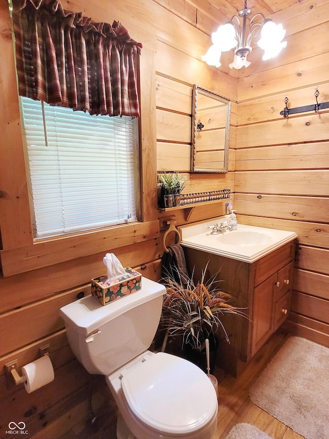 3715 Orchard Rd, Columbus, IN 47201 - half bathroom featuring vanity, wood walls, a chandelier, and wood finished floors