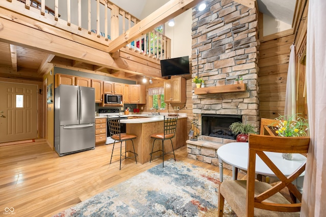 3715 Orchard Rd, Columbus, IN 47201 - kitchen with appliances with stainless steel finishes, light wood-type flooring, light countertops, a breakfast bar area, and a towering ceiling
