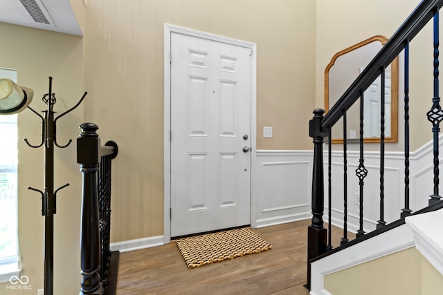 9476 Oakley Dr, Indianapolis, IN 46260 - foyer featuring stairs, wood finished floors, and a wainscoted wall