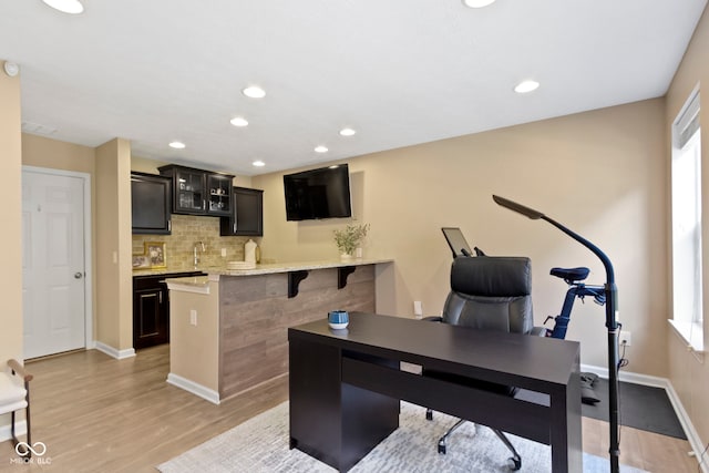 9476 Oakley Dr, Indianapolis, IN 46260 - office featuring light wood-type flooring, bar with sink, and recessed lighting