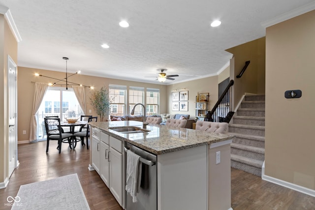 9476 Oakley Dr, Indianapolis, IN 46260 - kitchen with stainless steel dishwasher, a textured ceiling, ornamental molding, dark wood-style flooring, and a center island with sink