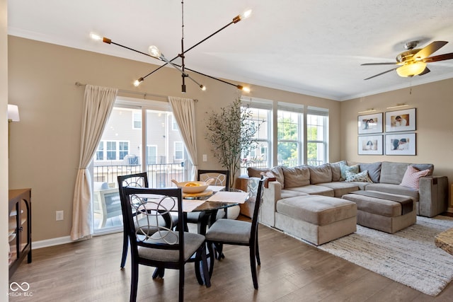 9476 Oakley Dr, Indianapolis, IN 46260 - dining space featuring crown molding, wood finished floors, a chandelier, and a ceiling fan