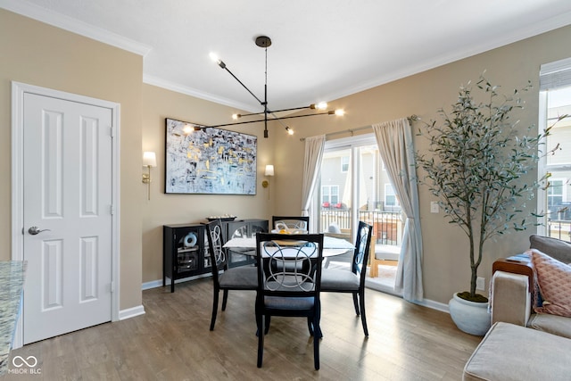 9476 Oakley Dr, Indianapolis, IN 46260 - dining space featuring a chandelier, light wood finished floors, and crown molding