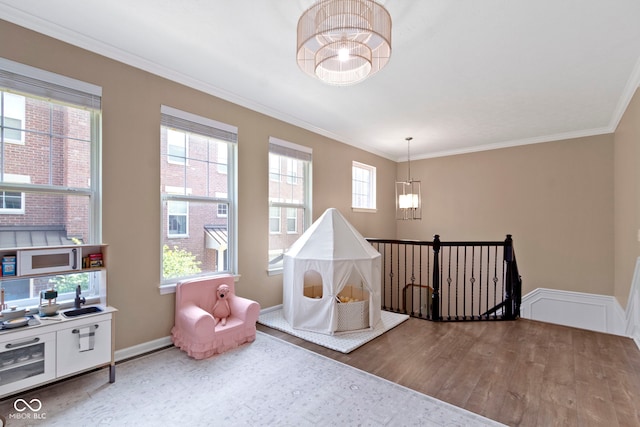 9476 Oakley Dr, Indianapolis, IN 46260 - rec room with wood finished floors, ornamental molding, and a chandelier