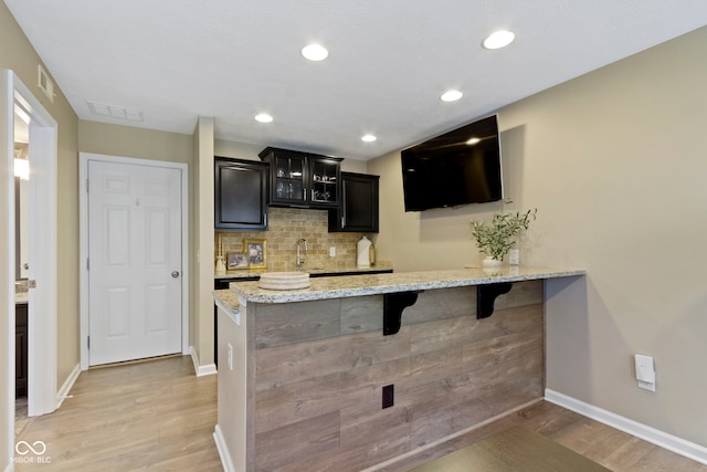 9476 Oakley Dr, Indianapolis, IN 46260 - bar area featuring light wood finished floors, backsplash, and recessed lighting