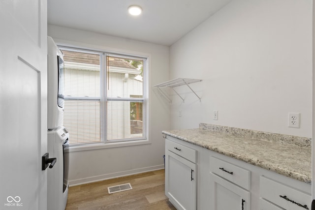 4129 Cornelius Ave, Indianapolis, IN 46208 - laundry area with stacked washing machine and dryer and light wood-type flooring