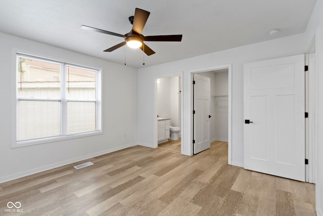 4129 Cornelius Ave, Indianapolis, IN 46208 - unfurnished bedroom featuring light wood-type flooring, a walk in closet, ensuite bathroom, a closet, and ceiling fan