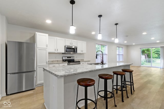 4129 Cornelius Ave, Indianapolis, IN 46208 - kitchen with stainless steel appliances, light wood-type flooring, white cabinetry, recessed lighting, and a breakfast bar area