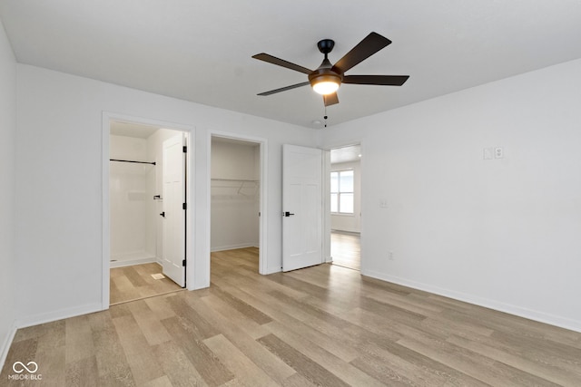 4129 Cornelius Ave, Indianapolis, IN 46208 - unfurnished bedroom with light wood-style floors, a spacious closet, a closet, ensuite bathroom, and a ceiling fan