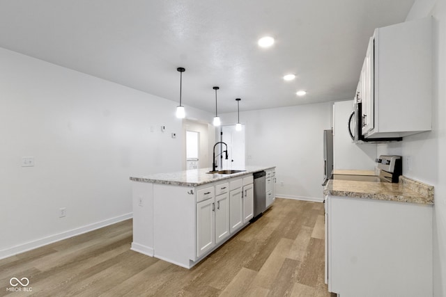 4129 Cornelius Ave, Indianapolis, IN 46208 - kitchen featuring appliances with stainless steel finishes, light wood-type flooring, a kitchen island with sink, white cabinets, and recessed lighting