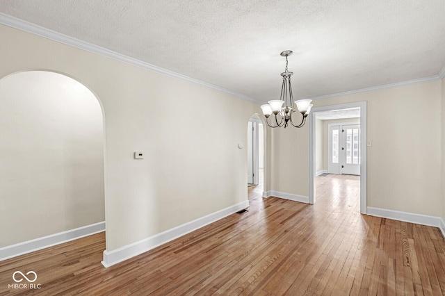 3760 Brill Rd, Indianapolis, IN 46227 - empty room with arched walkways, wood-type flooring, crown molding, a chandelier, and a textured ceiling