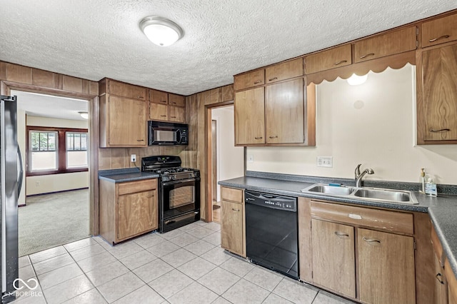 3760 Brill Rd, Indianapolis, IN 46227 - kitchen featuring black appliances, dark countertops, light tile patterned flooring, brown cabinetry, and a textured ceiling