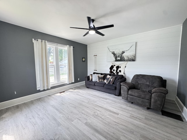 817 Pearl St, Covington, IN 47932 - living area featuring ceiling fan, wood finished floors, wood walls, and an accent wall