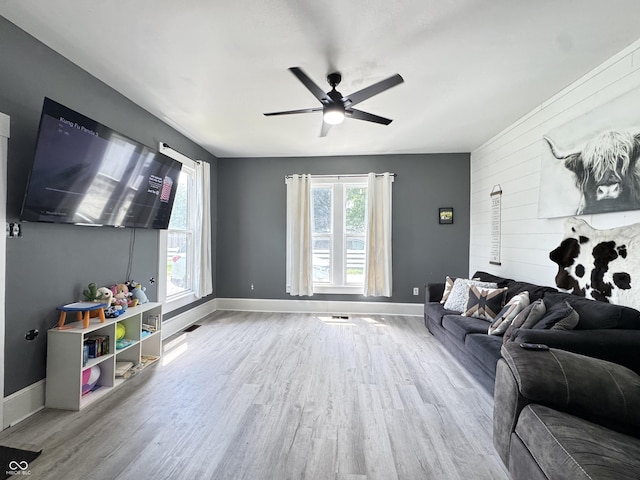 817 Pearl St, Covington, IN 47932 - living room featuring wood finished floors, a ceiling fan, an accent wall, and wood walls